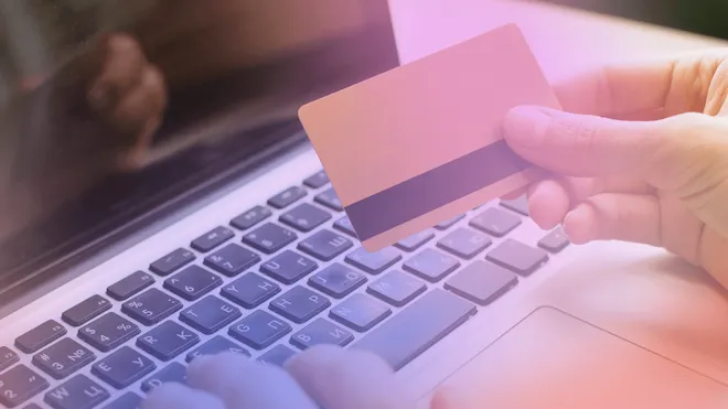 Person betalar med kort vid en bärbar dator
